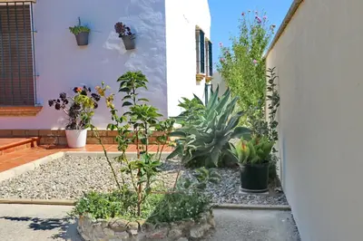 a garden with potted plants on the side of a house at Chalet Chaparrillo in Conil de la Frontera