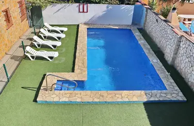 a swimming pool with lounge chairs next to a building at Apartamento Chinarejo in Conil de la Frontera