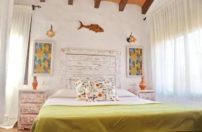 a bedroom with a large bed with a green bedspread at Apartamento Chinarejo in Conil de la Frontera
