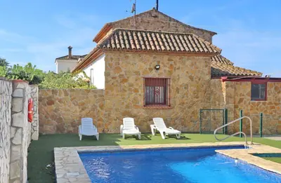 a house with a pool and two chairs and a house at Apartamento Chinarejo in Conil de la Frontera