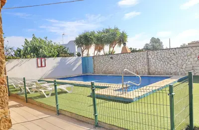 a tennis court with a net in front of a pool at Apartamento Chinarejo in Conil de la Frontera