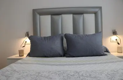 a bedroom with a bed with two pillows and two lamps at Apartamento en Conil con piscina in Conil de la Frontera