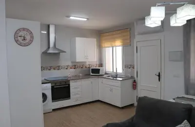 a kitchen with white cabinets and a stove top oven at Apartamento en Conil con piscina in Conil de la Frontera