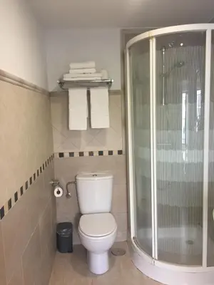 a bathroom with a toilet and a glass shower at La Casa de Abu - Casita con Encanto in Medina Sidonia