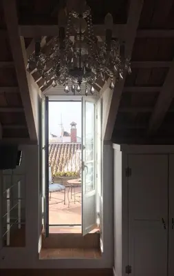 a chandelier hanging over a hallway with a patio at La Casa de Abu - Casita con Encanto in Medina Sidonia