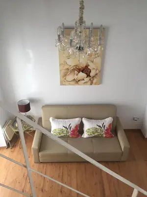 a living room with a couch and a chandelier at La Casa de Abu - Casita con Encanto in Medina Sidonia