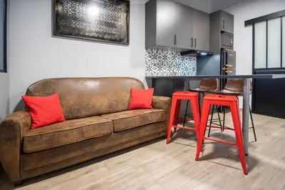 a living room with a brown couch and a table at Caleta Beach in Cádiz