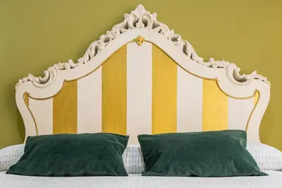 a headboard of a bed with two green pillows at Caleta Beach in Cádiz