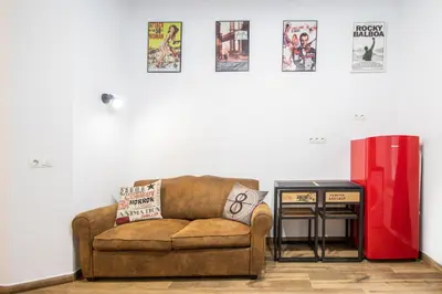 a living room with a couch and a red refrigerator at Caleta Beach in Cádiz