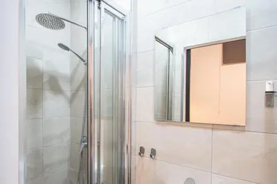 a bathroom with a shower and a mirror at Caleta Beach in Cádiz