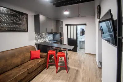 a living room and kitchen with a couch and a bar at Caleta Beach in Cádiz