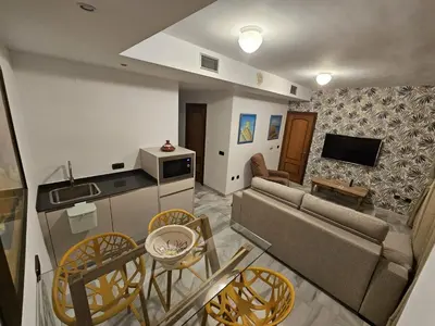 a living room with a table and a door at Hotel La Española in Chipiona
