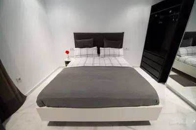 a bedroom with a large bed in a white room at Casa Margot Cádiz Grupo AC Gestión in Cádiz