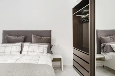 a bedroom with a bed and a closet at Casa Margot Cádiz Grupo AC Gestión in Cádiz