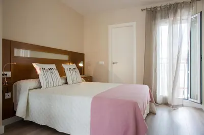 a bedroom with a large bed and a window at La Posada del Mercado in Cádiz