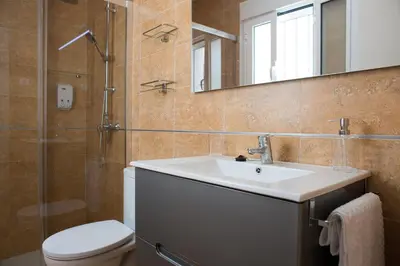 a bathroom with a sink and a toilet and a mirror at La Posada del Mercado in Cádiz