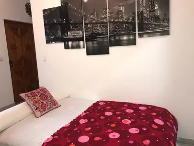a room with a bed with a red blanket at Apartamento Conocedores in Jerez de la Frontera
