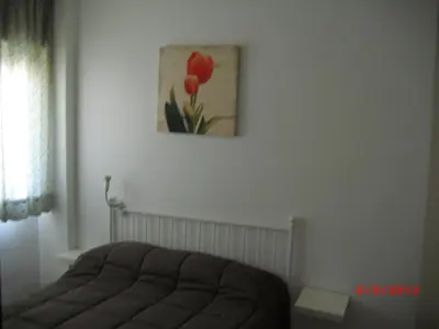 a bedroom with a couch and a painting on the wall at Apartamento Valdelagrana in El Puerto de Santa María