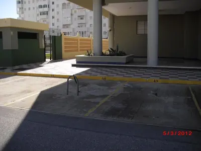 a parking lot with a yellow curb in front of a building at Apartamento Valdelagrana in El Puerto de Santa María
