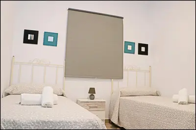 two beds in a room with a large screen on the wall at Apartamento rural en Conil in Conil de la Frontera