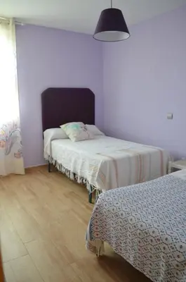 a bedroom with two beds and a lamp at Apartamento Plaza Castañuelas in Jerez de la Frontera