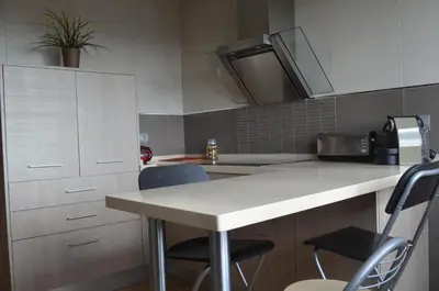 a kitchen with a table and two chairs and a sink at Apartamento Plaza Castañuelas in Jerez de la Frontera