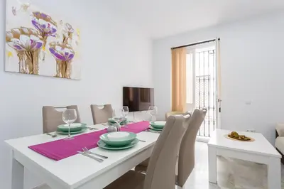 a white dining room with a white table and chairs at Casa TANGUILLOS de Cadiz in Cádiz