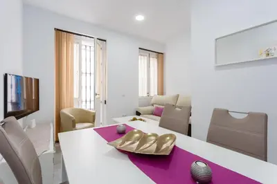 a dining room with a white table with gold shoes on it at Casa TANGUILLOS de Cadiz in Cádiz
