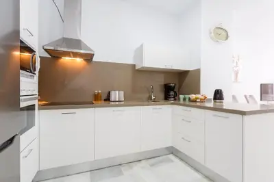 a white kitchen with white cabinets and appliances at Casa TANGUILLOS de Cadiz in Cádiz