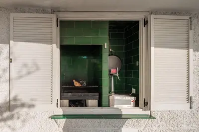 a window with a green tiled wall with a stove at La Torre Verde, Villa EN la playa, El Puerto de Santa María in El Puerto de Santa María