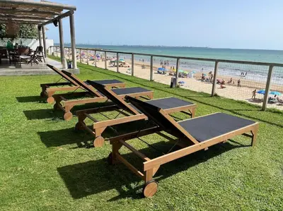 a row of loungers sitting on the grass near the beach at La Torre Verde, Villa EN la playa, El Puerto de Santa María in El Puerto de Santa María