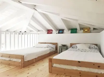 two beds in a room with white walls at La Torre Verde, Villa EN la playa, El Puerto de Santa María in El Puerto de Santa María