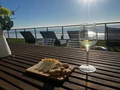 a glass of wine and a plate of cheese and crackers at La Torre Verde, Villa EN la playa, El Puerto de Santa María in El Puerto de Santa María