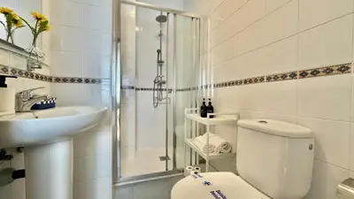 a bathroom with a toilet and a sink and a shower at SibsSanlucar Reina 2 del Centro Parking in Sanlúcar de Barrameda
