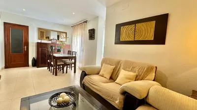 a living room with a couch and a dining room at SibsSanlucar Reina 2 del Centro Parking in Sanlúcar de Barrameda