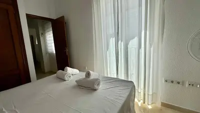 a bedroom with a bed with towels on it at SibsSanlucar Reina 2 del Centro Parking in Sanlúcar de Barrameda