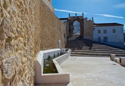 a stone wall with steps and a building at Apartamento Thebussem in Medina Sidonia