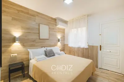 a bedroom with a large bed and a bathroom at Hospederia IMAR by Cadiz4Rentals in Cádiz