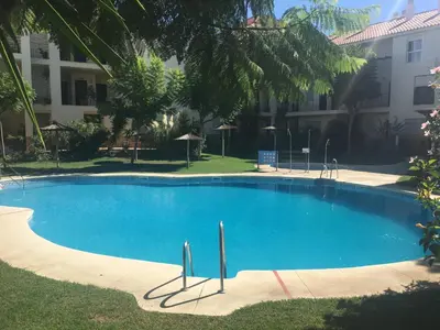 a large blue swimming pool next to a building at Atico Costa Ballena golf y playa parking&wifi in Costa Ballena