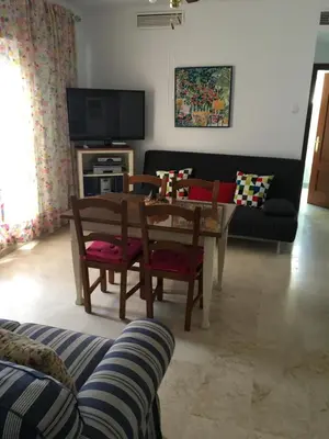 a living room with a couch and a table at Atico Costa Ballena golf y playa parking&wifi in Costa Ballena