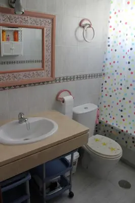 a bathroom with a sink and a toilet and a mirror at Atico Costa Ballena golf y playa parking&wifi in Costa Ballena