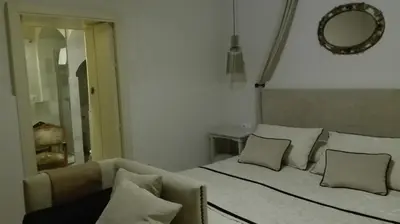 a bedroom with a bed with pillows and a mirror at Estudio Bizcocheros in Jerez de la Frontera