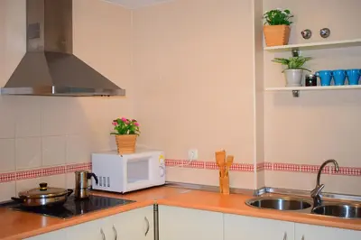a kitchen with a sink and a microwave at Apartamento Costa Ballena con WIFI in Rota