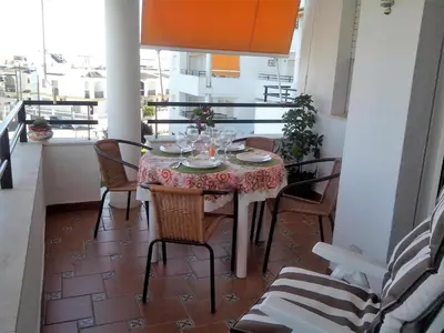 a table with wine glasses on a balcony at Apartamento Pepi Chipiona in Chipiona