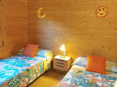 two beds in a room with wooden walls at Cabaña Blanca Roche Jorge in Conil de la Frontera