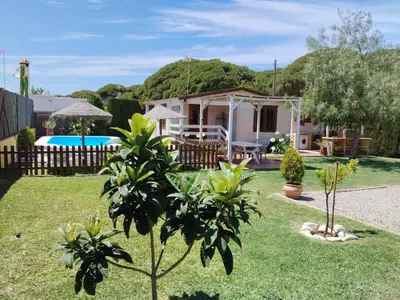a house with a garden with trees in the yard at Cabaña Blanca Roche Jorge in Conil de la Frontera