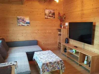 a living room with a couch and a flat screen tv at Cabaña Blanca Roche Jorge in Conil de la Frontera