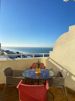 a table on a balcony with a view of the ocean at Atico Apartamento Loft Playa Victoria Cadiz in Cádiz