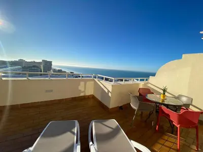 a balcony with a table and chairs and the ocean at Atico Apartamento Loft Playa Victoria Cadiz in Cádiz