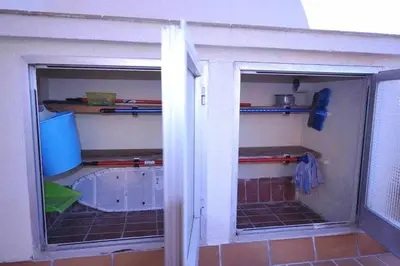 a garage with two glass doors in a room at Atico Apartamento Loft Playa Victoria Cadiz in Cádiz